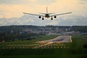 avion qui atterrit avec des montagnes en fond