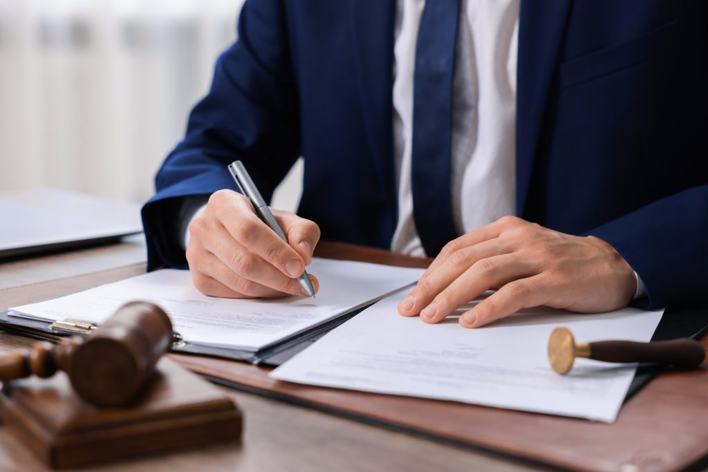 Signature d’un document dans une étude notariale lors du traitement des formalités d’urbanisme liées à un dossier immobilier