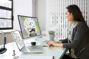 Analyse d’un plan cadastral et d’une carte immobilière sur ordinateur pour vérifier les servitudes et les informations d’un bien avant la signature d’un acte notarié