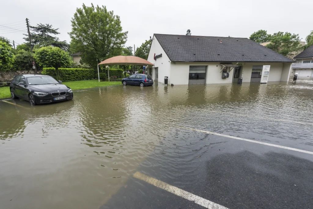 Rue et habitations partiellement inondées après une montée des eaux dans une zone exposée au risque d’inondation